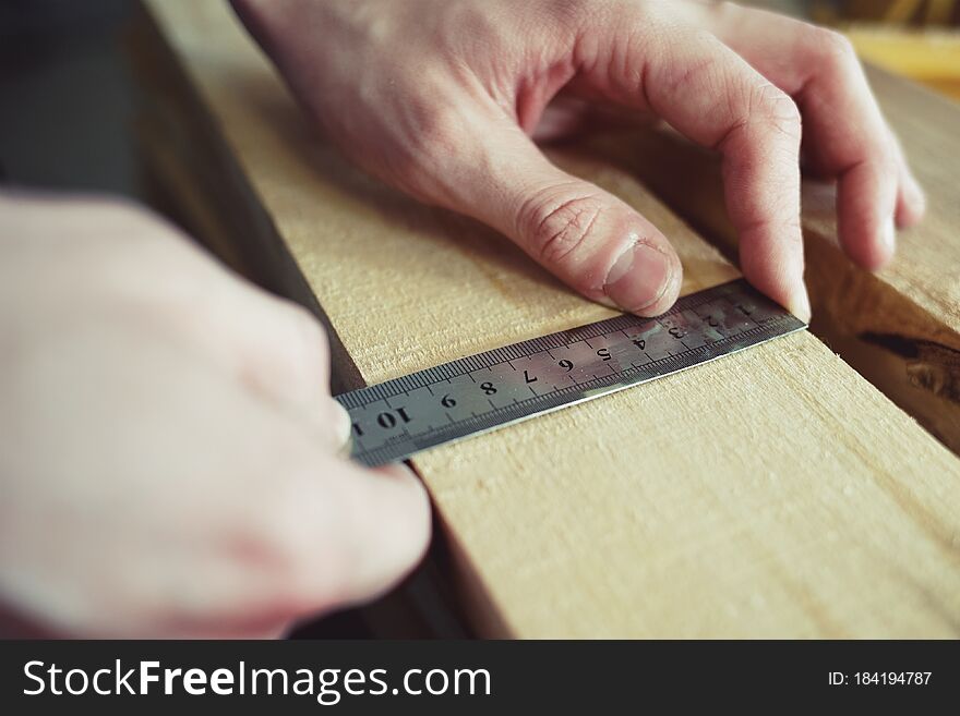 Construction And Repair. Men& X27;s Hands Line Measure The Width Of A Wooden Board. Hands With A Close-up Tool