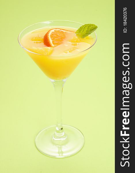 Orange cocktail with mint on green background