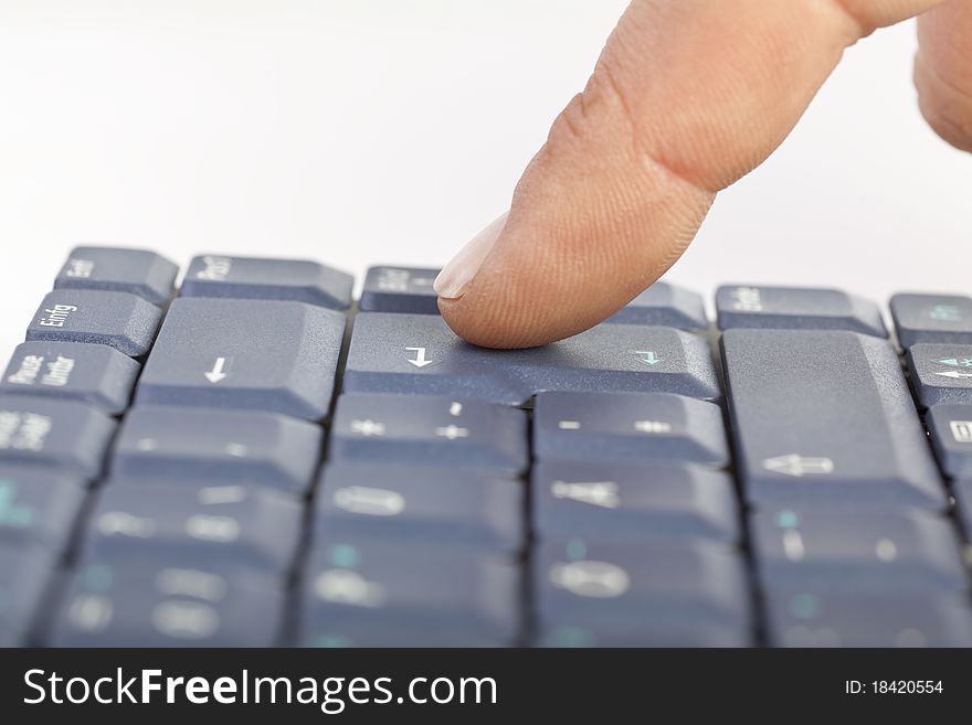Male finger press enter on grey keyboard