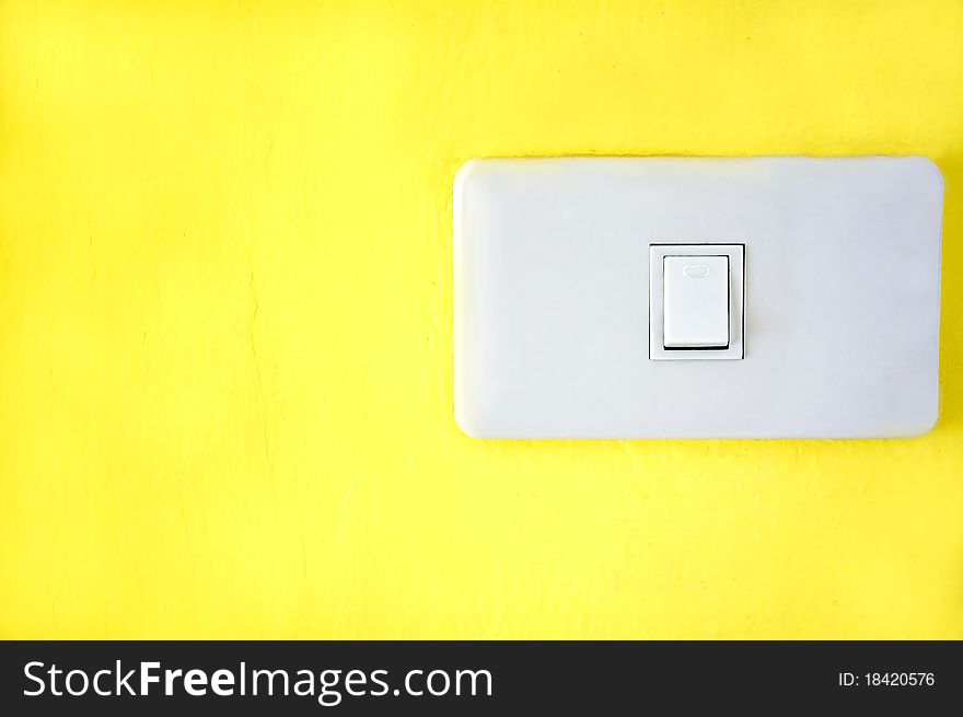 Light switch on yellow wall.