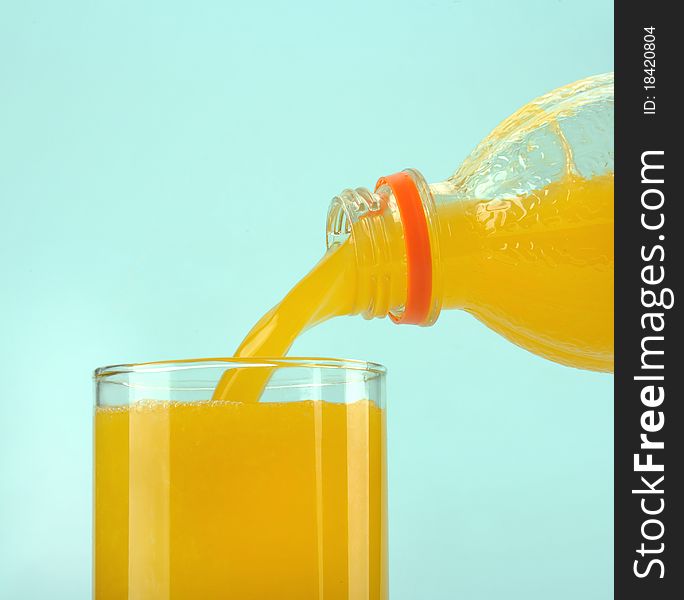 Glass with orange juice on the blue