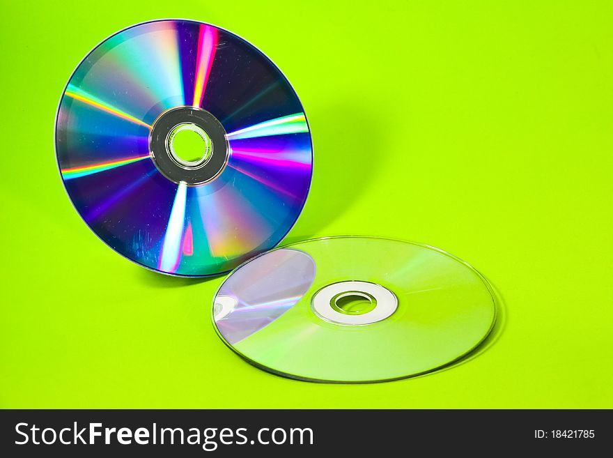 Two CDs and their mirror with green background. Two CDs and their mirror with green background