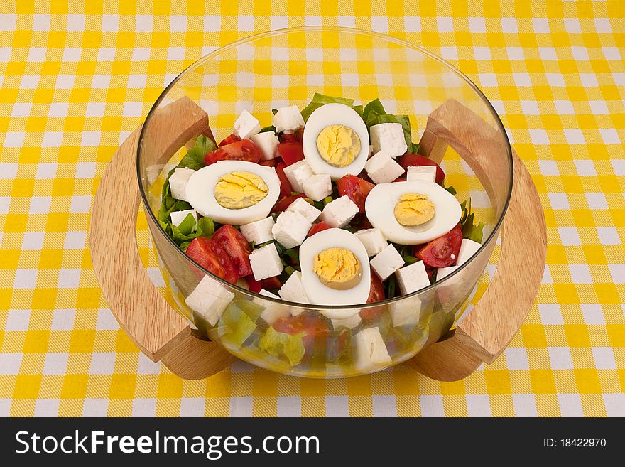 Fresh salad with eggs in a nice glass and wood bowl