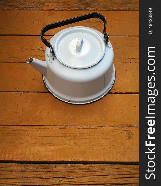 Old classic kettle on the wooden floor. Old classic kettle on the wooden floor