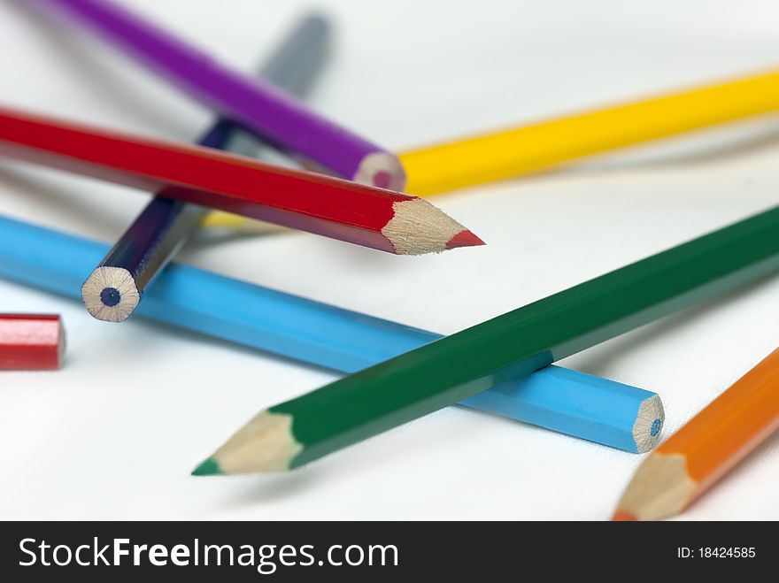 Color pencils scattered on white background