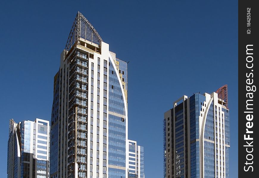 New towerlike buildings against a background of blue sky. New towerlike buildings against a background of blue sky