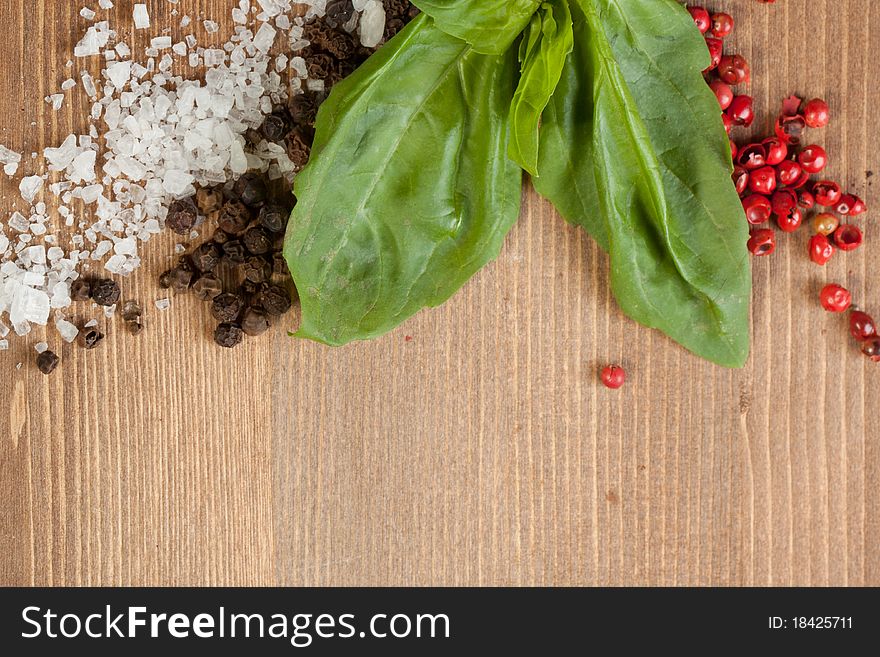 Border os fresh herbs, salt and pepper's mix on wooden background