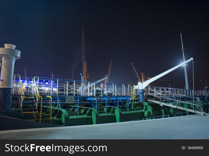 A picture of an harbour taken during the night. Sea, crane, lights and oil platform create the sceene. A picture of an harbour taken during the night. Sea, crane, lights and oil platform create the sceene.