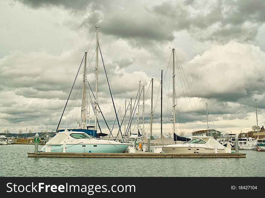 Boats in moorage against cloudy sky.