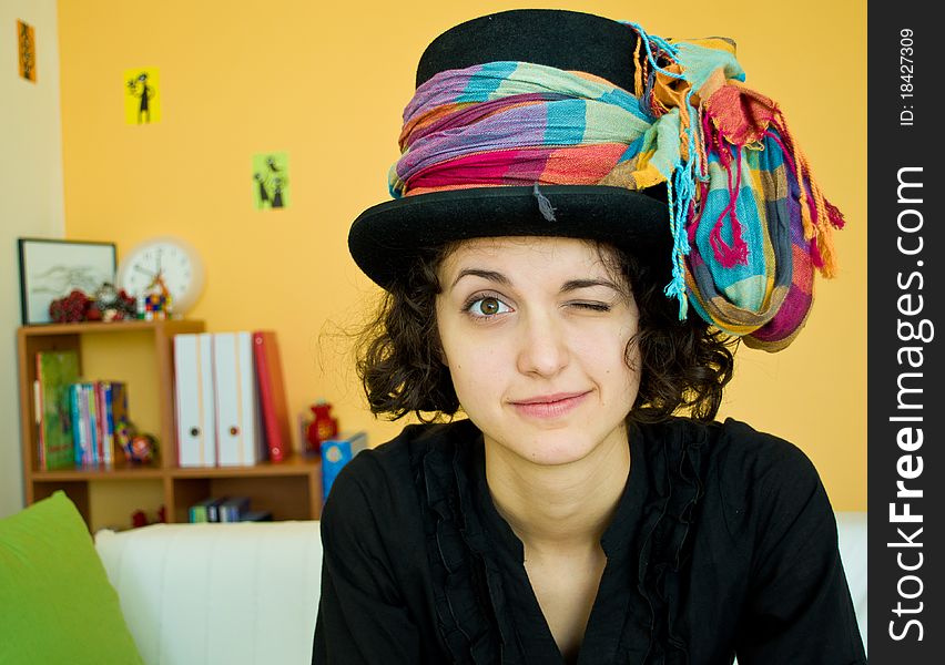 Portrait of a young woman with a black magician hat and a colorful scarf. Portrait of a young woman with a black magician hat and a colorful scarf