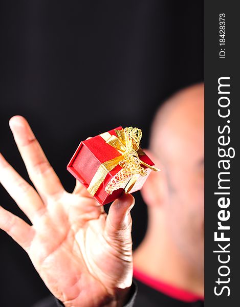 A man gives a red gift box