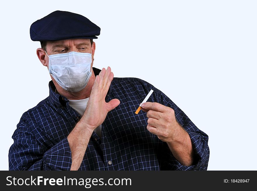 Man with a mask on, pushing away a cigarette which is in his other hand, resisting the temptation of smoking. Man with a mask on, pushing away a cigarette which is in his other hand, resisting the temptation of smoking.