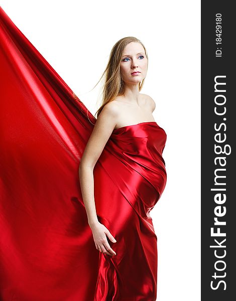 A beautiful young pregnant woman in red on a white background