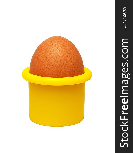 Fresh hen's egg in a yellow eggcup (isolated).