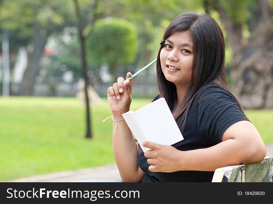 Women sitting in the park and hold a white card. Women sitting in the park and hold a white card.