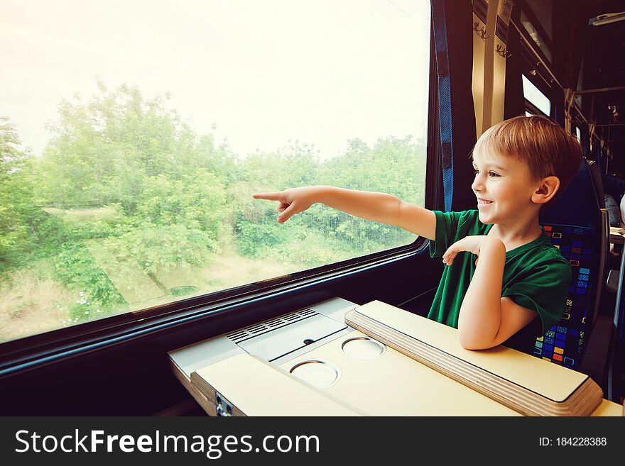Cute boy traveling by train. Summer vacation. Little kid in a high speed express train on family vacation in Europe. Travel by railway. Children in rail way wagon