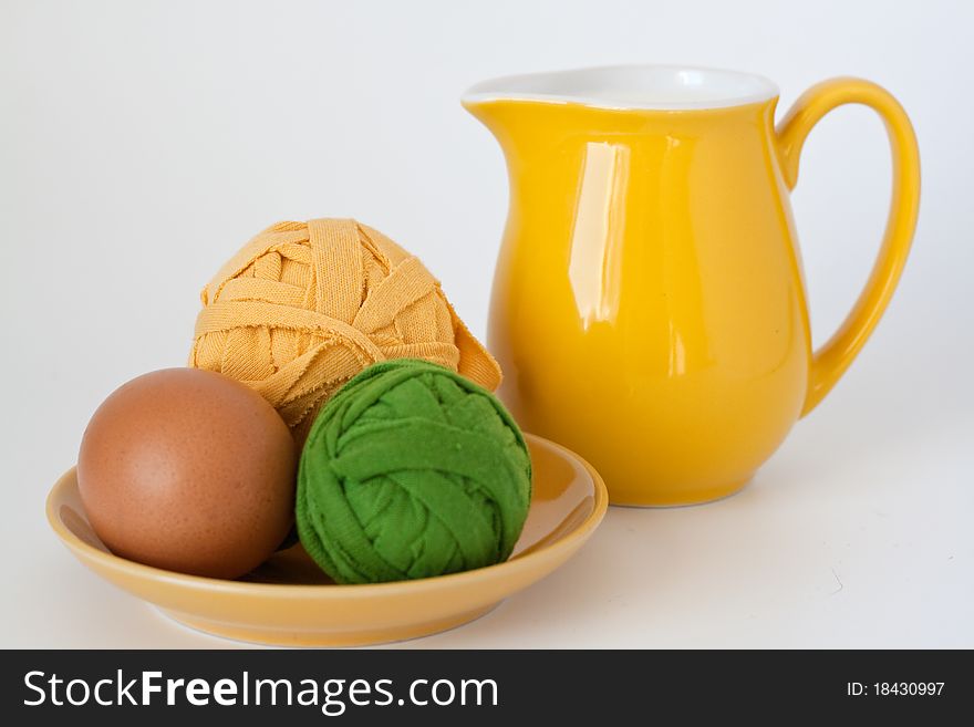 Pitcher of milk, egg, and two coil threads for knitting. Pitcher of milk, egg, and two coil threads for knitting