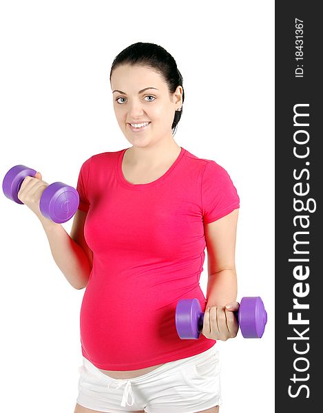 Young pregnant woman making exercise with dumb bells