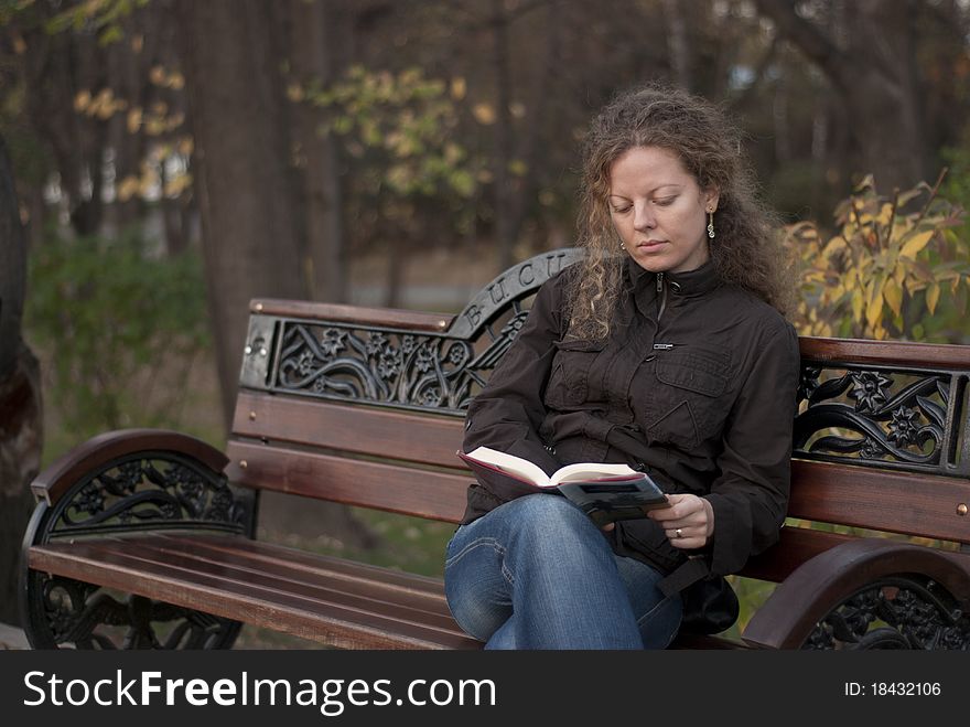 Curly girl reading in a park