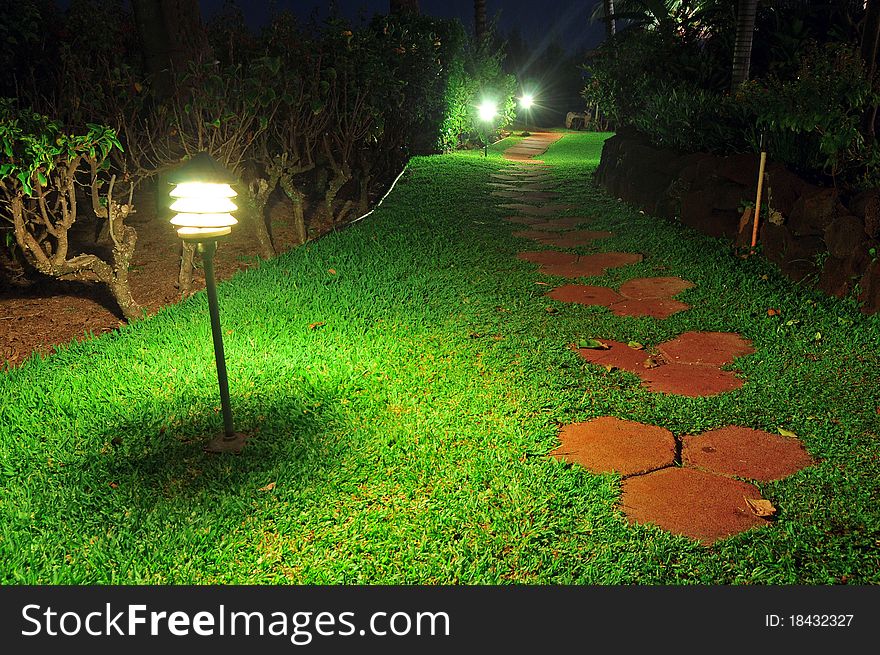 Pathway stones in a beautiful garden walkway with lamps at night. Pathway stones in a beautiful garden walkway with lamps at night