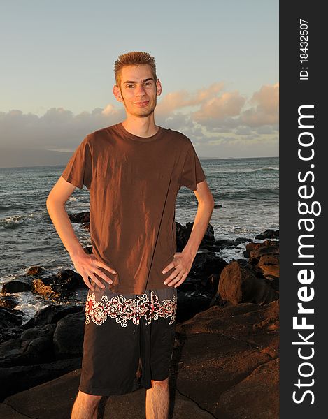 Single young 19 year old teenage adult standing on the beach smiling. Single young 19 year old teenage adult standing on the beach smiling