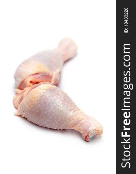 Close up of two raw chicken drumsticks isolated on white background.