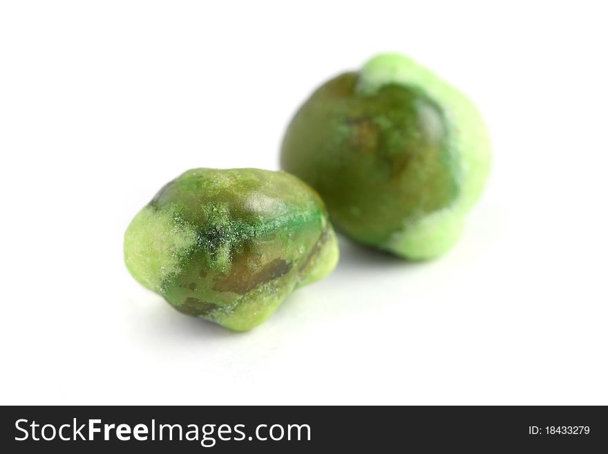 Macro shot of two wasabi coated green peas isolated on white background.