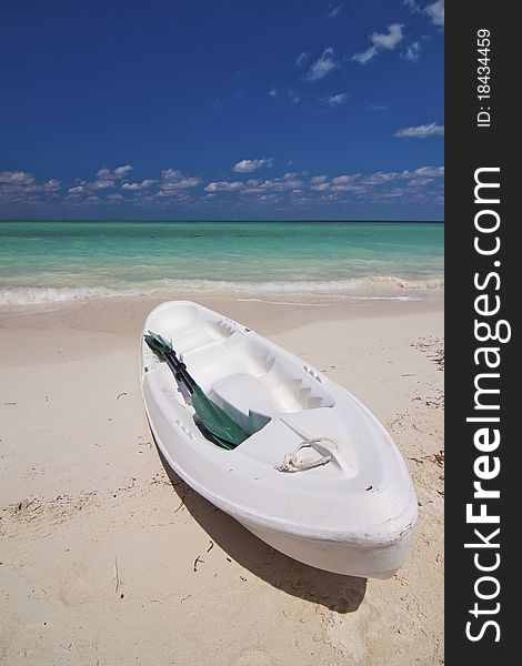 A view of a lone kayak can on a beautful white sandy beach. This shot was taken on Isla Pasion, a popular tourist destination for cruise ship passengers when visiting Cozumel, Mexico. The beach is a popular wedding location and was once used for a location shoot for a Corona beer ad. A view of a lone kayak can on a beautful white sandy beach. This shot was taken on Isla Pasion, a popular tourist destination for cruise ship passengers when visiting Cozumel, Mexico. The beach is a popular wedding location and was once used for a location shoot for a Corona beer ad.