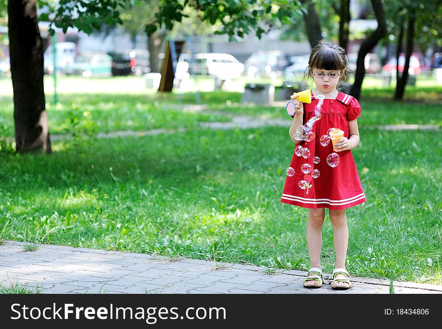 Beauty little girl with long dark hair in red old style dress with soap bubbles. Beauty little girl with long dark hair in red old style dress with soap bubbles