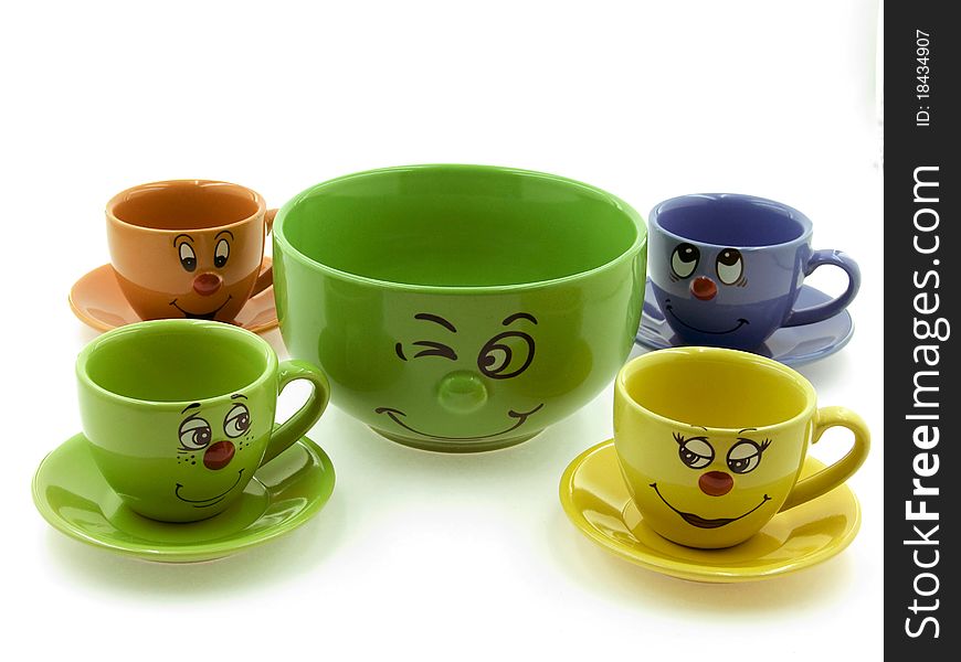 Four kid's cups beside a green bowl on the White Background