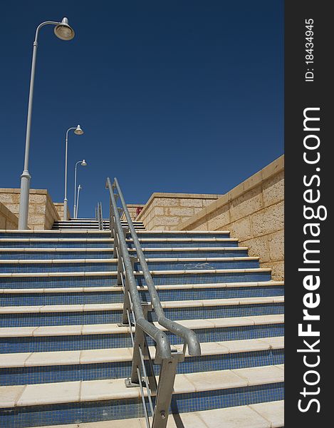 RAW-file of wide steps with with handrail and streetlights in new housing development area in Perth, Western Australia - with spotless clean blue sky as background and copy space. RAW-file of wide steps with with handrail and streetlights in new housing development area in Perth, Western Australia - with spotless clean blue sky as background and copy space.