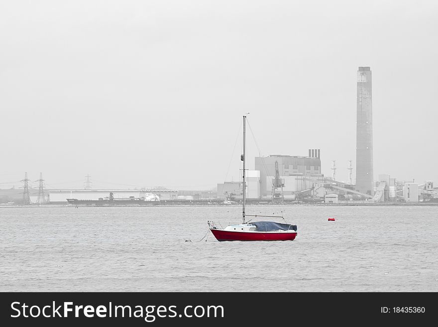 Red sailing boat anchored on mooring, Medway river, UK. Red sailing boat anchored on mooring, Medway river, UK