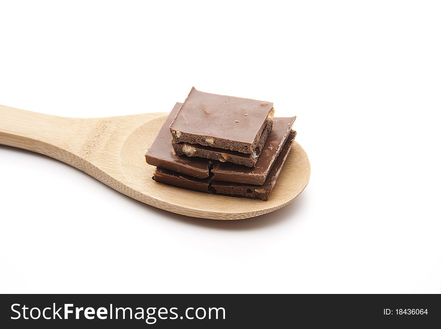 Chocolate with nut onto spoons and broken