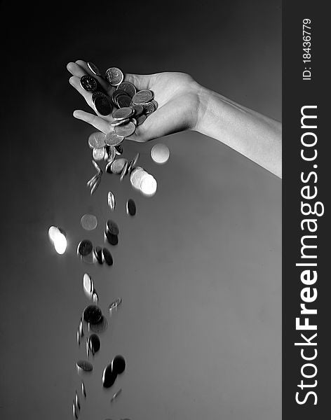 Hand dropping coins in black and white. Hand dropping coins in black and white