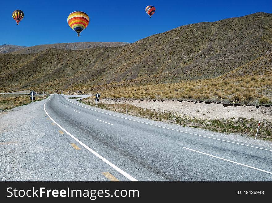 Colorful balloon flying above road to Omarama