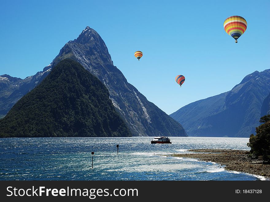 Colorful balloon flying above Milford Sound, NZ. Colorful balloon flying above Milford Sound, NZ