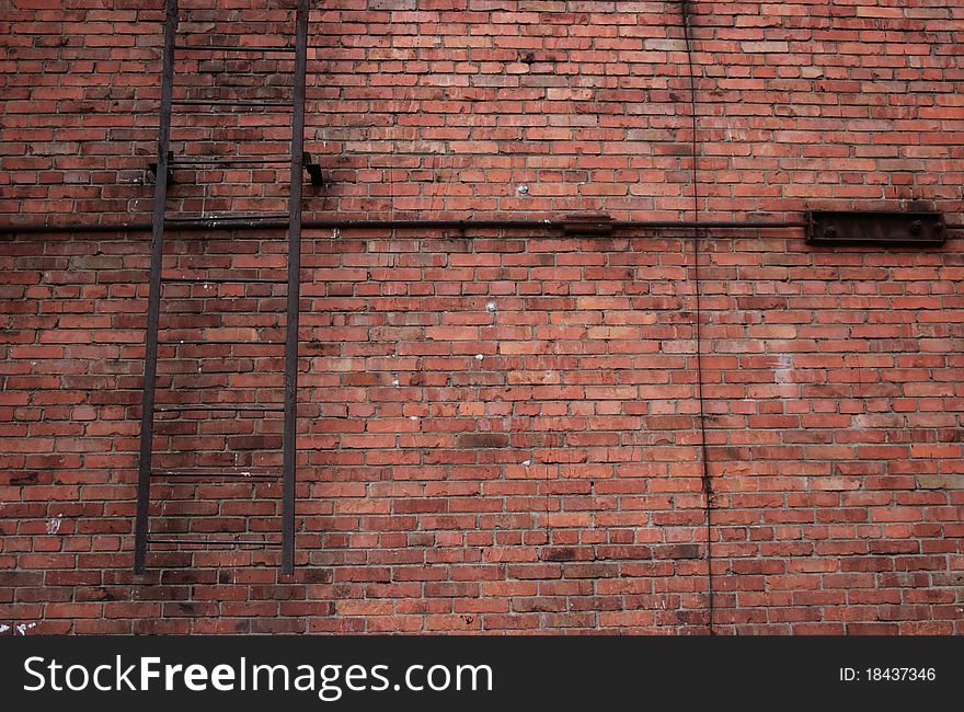 Red brick wall and emergency metal stairs on it. Red brick wall and emergency metal stairs on it.