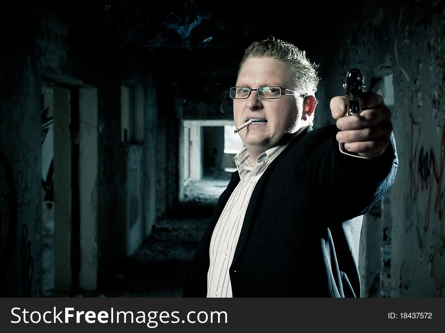 Suit dressed man aiming wiht gun in abandoned building. Suit dressed man aiming wiht gun in abandoned building