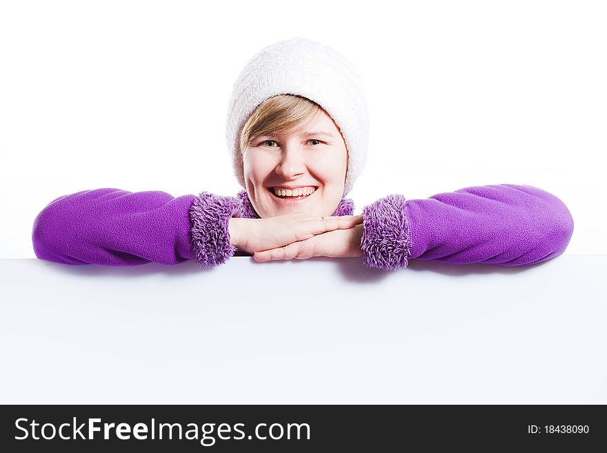 Young woman in a warm cap and a sweater showing empty white board