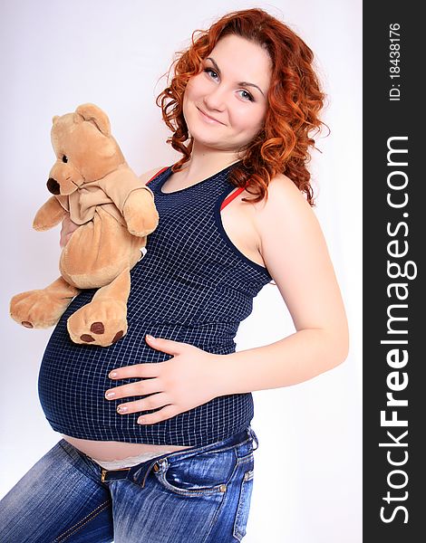 Heavily pregnant womans tummy with teddy bear