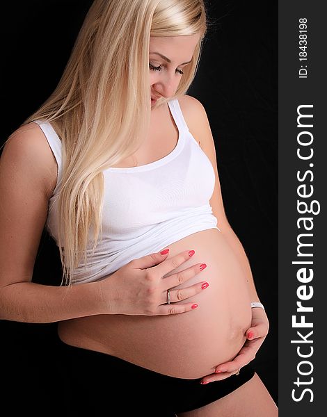Young pregnant blond woman holding her belly