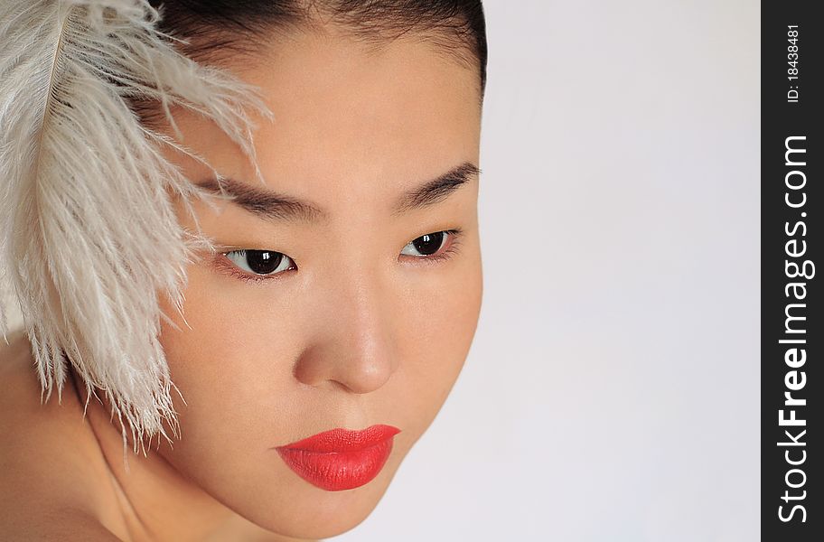 A beautiful young Asian girl with a feather. A beautiful young Asian girl with a feather