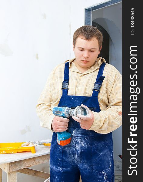 Young worker hold drill in hand. Home renovation theme