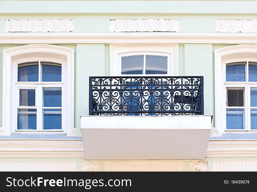 Windows and balcony with grate on wall of ancient building, Russia. Windows and balcony with grate on wall of ancient building, Russia.