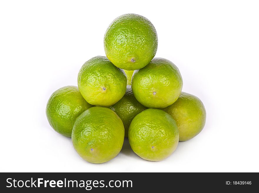 Pile of fresh limes across white
