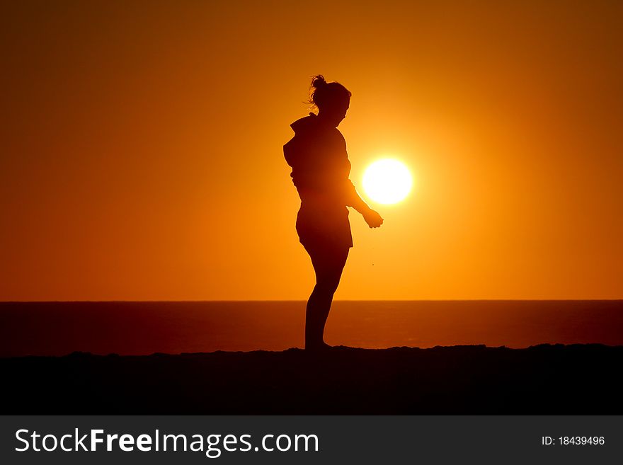 Silhouette of girl standing in sunset at atlantic coast