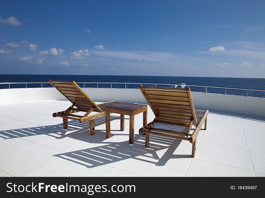 Deck chair on cruising ship are overlooking blue sky and blue indian ocean.