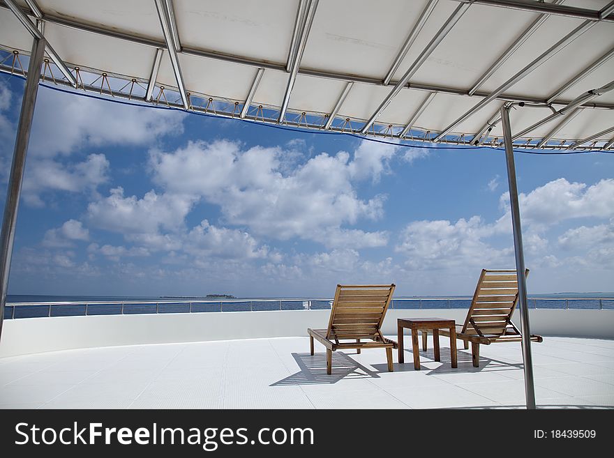 Deck chair on cruising ship are overlooking blue sky and blue indian ocean.