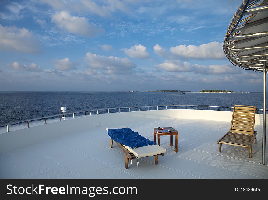 Deck chair on cruising ship are overlooking blue sky and blue indian ocean.