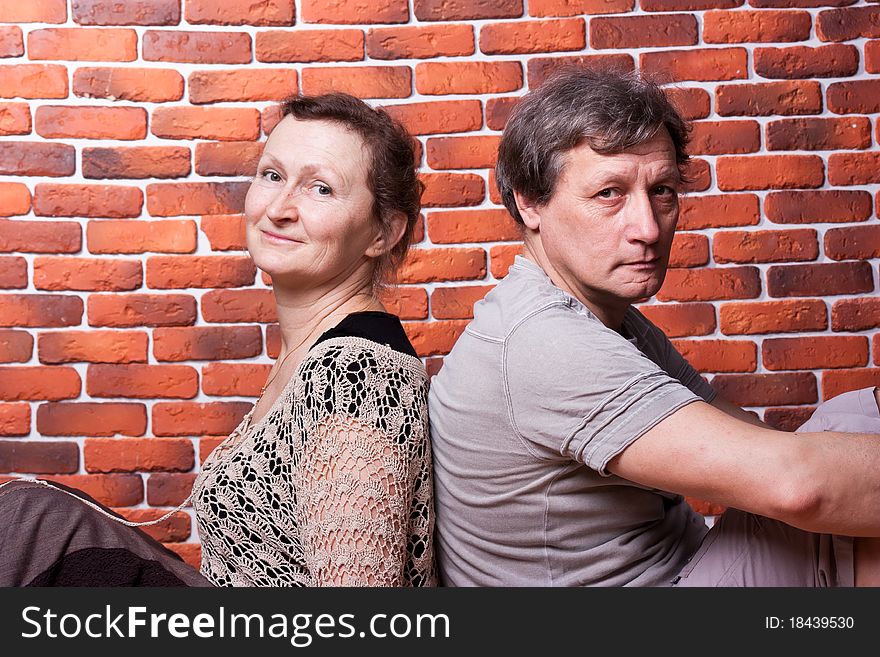 Happy seniors couple in love against brick wall